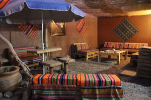 Habitación con mesa, sombrilla y sillas. en Misky Wasi en San Pedro de Atacama
