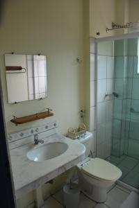 a bathroom with a sink and a toilet and a shower at Pousada 3 Corações in Penedo