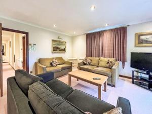 a living room with two couches and a television at Chalet Glen View by Interhome in Spean Bridge