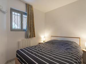 een slaapkamer met een bed en een raam bij Apartment Les Deux voiles-4 by Interhome in Cogolin