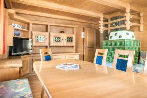 jadalnia z drewnianym stołem i krzesłami w obiekcie Chalet Matzhof w mieście Leogang