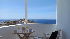 a balcony with a table and two glasses of wine at Aegean Dream Apartments in Tinos