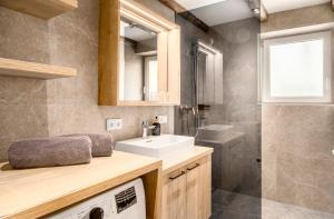 łazienka z umywalką i pralką w obiekcie Chalet Matzhof w mieście Leogang