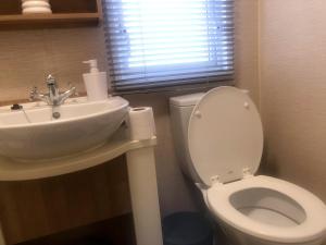 a bathroom with a white toilet and a sink at Rivington Retreat in Heysham