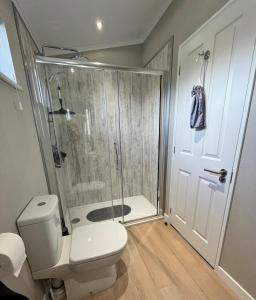 a bathroom with a shower and a toilet and a shower backdoor at Waterside Retreat Heron Lakes Nr Beverley in Beverley