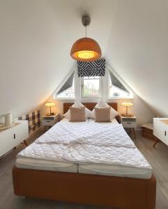 een slaapkamer met een groot bed en 2 ramen bij Friedenstr_ 37 Wg_ 5 in Zingst