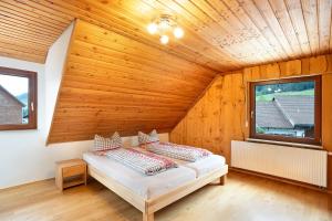- une chambre avec un lit dans une pièce en bois dans l'établissement Wohnung Kuhblick, à Baiersbronn