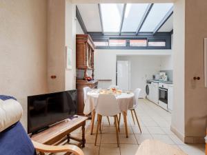 a living room with a table with chairs and a tv at Holiday Home Gambetta by Interhome in Deauville +29 photos