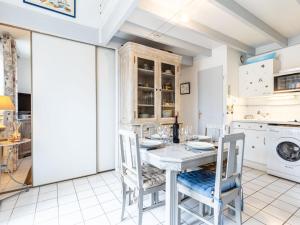 a kitchen with a table and chairs and a washing machine at Apartment Hameau de Talaris-17 by Interhome in Les Mathes