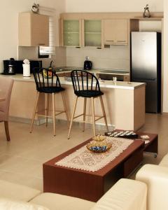 eine Küche mit 2 Stühlen, einem Tisch und einer Theke in der Unterkunft Luxury Rhodian Panorama in Ixia