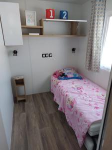 a small bedroom with a bed and a window at mobil home jordy a gastes 714 in Gastes
