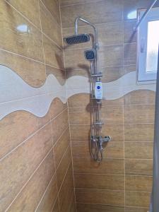 La salle de bains est pourvue d'une douche avec un pommeau de douche. dans l'établissement Apartman Vuković, à Foča