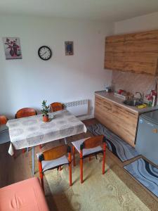 een keuken met een tafel, stoelen en een spoelbak bij Apartman Vuković in Foča