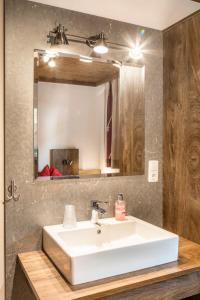łazienka z białą umywalką i lustrem w obiekcie Chalet Matzhof w mieście Leogang +32 zdjęcia
