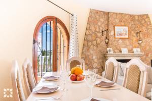 ein Esszimmer mit einem Tisch und einer Obstschale in der Unterkunft Villa Teresa by Abahana Villas in Calpe