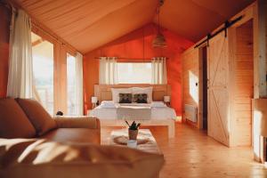 a bedroom with a bed and a couch in a room at Glamping Mazury - Przystań Jeziorany in Jeziorany