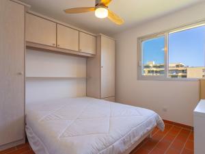 Schlafzimmer mit einem Bett und einem Deckenventilator in der Unterkunft Apartment Parcs du Lavandou-10 by Interhome in Le Lavandou