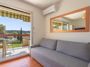 ein Wohnzimmer mit einem Sofa und einem großen Fenster in der Unterkunft Apartment Parcs du Lavandou-10 by Interhome in Le Lavandou