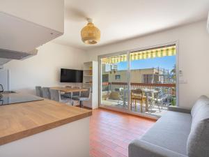 eine Küche und ein Wohnzimmer mit einem Sofa und einem Tisch in der Unterkunft Apartment Parcs du Lavandou-10 by Interhome in Le Lavandou