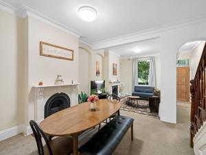 a living room with a table and a fireplace at Fancy 4 BR House with Parking - ICC&Darling Harbour-8 mins walk in Sydney