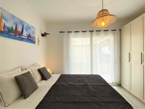 ein Schlafzimmer mit einem großen Bett und einem Fenster in der Unterkunft Apartment Perla dell'Isola by Interhome in Trinità dʼAgultu