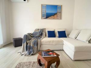 uma sala de estar com um sofá branco e uma mesa em Apartment Perla dell'Isola by Interhome em Trinità d'Agultu e Vignola