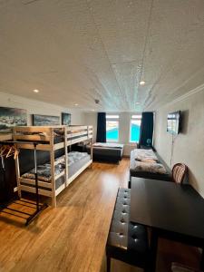 Zimmer mit 2 Etagenbetten und einem Sofa in der Unterkunft Fisherinn, Hostel and Cultural Center in Stokkseyri