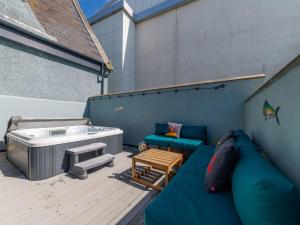 a patio with a hot tub and a couch and a table at Holiday Home Towan by Interhome in Newquay