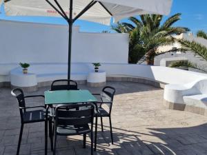 a table and chairs with an umbrella on a patio at Gaviotas Beach Golf Love 11 in Almerimar