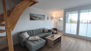 レリクにあるFerienwohnung OstseeStern Rerik mit Saunaのソファと階段のあるリビングルーム