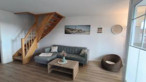 レリクにあるFerienwohnung OstseeStern Rerik mit Saunaのソファと階段のあるリビングルーム