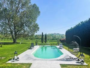 una piscina con due sedie e un gazebo di Apartment Tenuta Beatrice-1 by Interhome a CastellʼAlfero