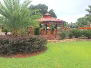 a gazebo in a park with a palm tree at Deluxe Inn - Savannah in Savannah