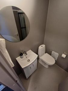 ein Badezimmer mit einem WC, einem Waschbecken und einem Spiegel in der Unterkunft Room 5 On Pedestrian Street Sby - Free Parking in Sæby