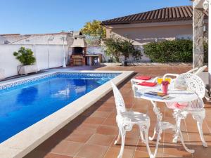 a patio with a table and chairs next to a pool at Villa Villa Capri by Interhome in Miami Platja