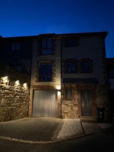 a building with two garage doors at night at 4 Bed House in Lovely Cornish Town in Saint Columb Major