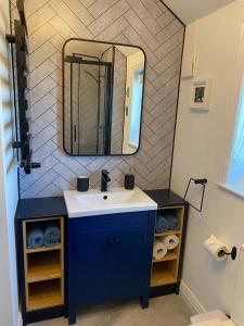 a bathroom with a blue sink and a mirror at 4 Bed House in Lovely Cornish Town in Saint Columb Major +21 photos