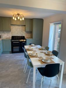 a kitchen with a white table with chairs and a stove at 4 Bed House in Lovely Cornish Town in Saint Columb Major