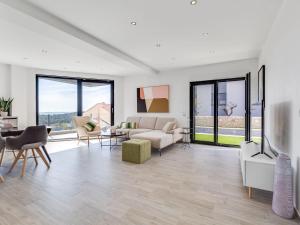 a living room with white furniture and large windows at Apartment Minimalist by Interhome in Šibenik