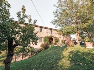 een oud stenen huis met een grasveld bij Holiday Home Mirandola by Interhome in Vicchio