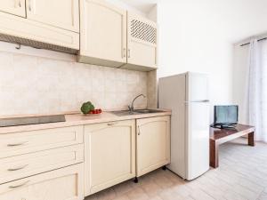 een keuken met witte kasten en een koelkast bij Apartment Santa Maria by Interhome in Castiglione della Pescaia