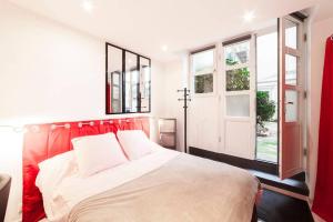 a bedroom with a bed with a red headboard and a window at The studio at Saint-Jean cathedral, old town AIL in Lyon