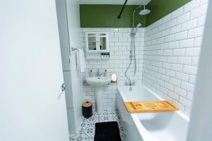 a white bathroom with a tub and a sink at Grace House - 15 Minutes To Central London in Thamesmead