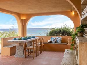 a patio with a table and chairs and the ocean at Apartment 0-1-M - Marineledda by Interhome in Golfo Aranci