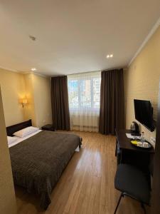 Pokój hotelowy z łóżkiem i biurkiem w obiekcie Passage Hotel w mieście Tarnopol