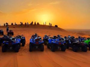 un gruppo di quad e persone su una duna di sabbia di Berbers Luxury Camp a Merzouga