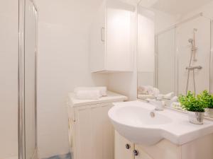 Un baño blanco con lavabo y espejo. en Apartment L'Espelido-7 by Interhome, en Saint-Aygulf