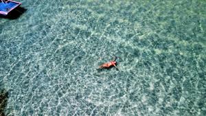 a person swimming in the water in the ocean at Angá Beach Hotel in São Miguel dos Milagres
