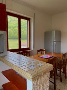una cucina con tavolo e piano di lavoro di Avventura e Relax a Bagnasco 2 a Bagnasco