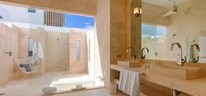 uma casa de banho com 2 lavatórios e uma grande janela em Beachfront House, Meads Bay Beach em Meads Bay